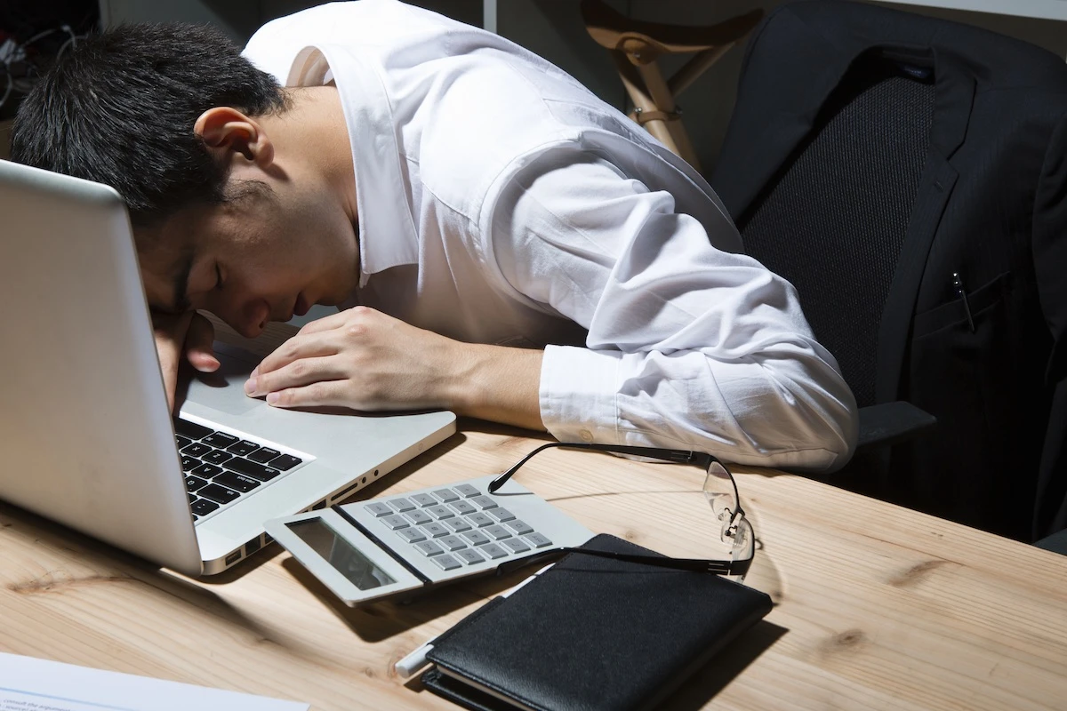 toxic productivity digital age sleeping at laptop